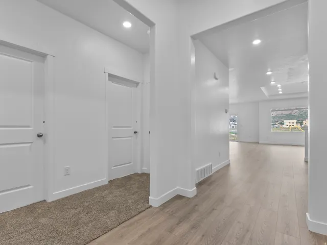 Recessed lighting, wood-finish flooring, two-panel interior doors, and neutral wall tones
