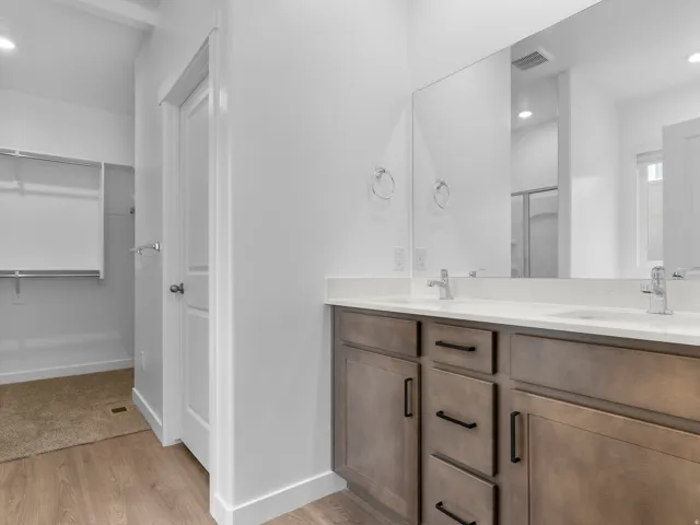 Dual vanity with white countertops, undermount sinks, and chrome-finish faucets
