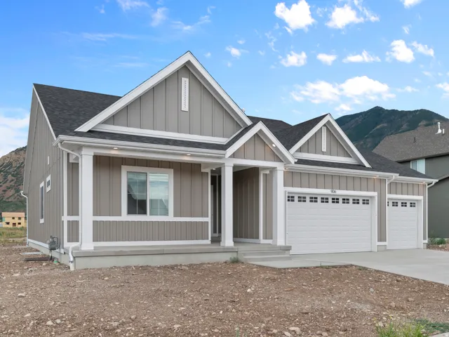 Contemporary ranch-style residence featuring a covered entry, board and batten siding, and a two-car garage