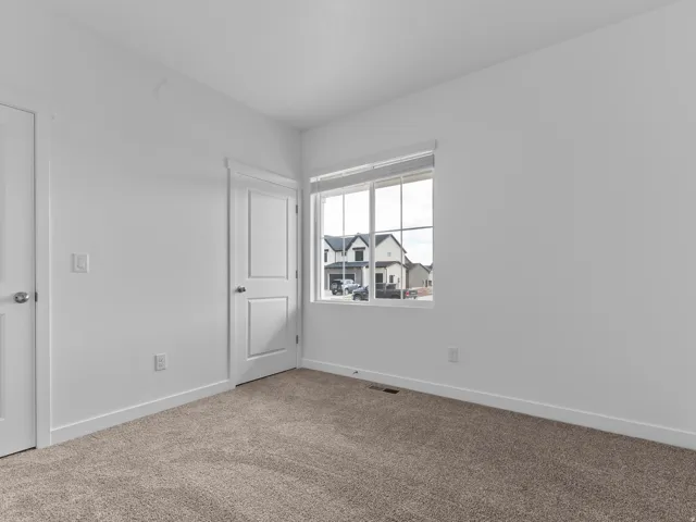 Neutral-toned carpeting, white walls, and white trim