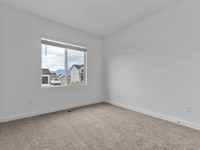 Neutral wall paint with carpet flooring and a large window