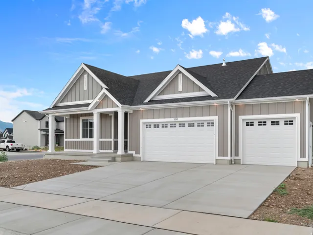Siding exterior with white trim, covered front porch, and an attached two-car garage