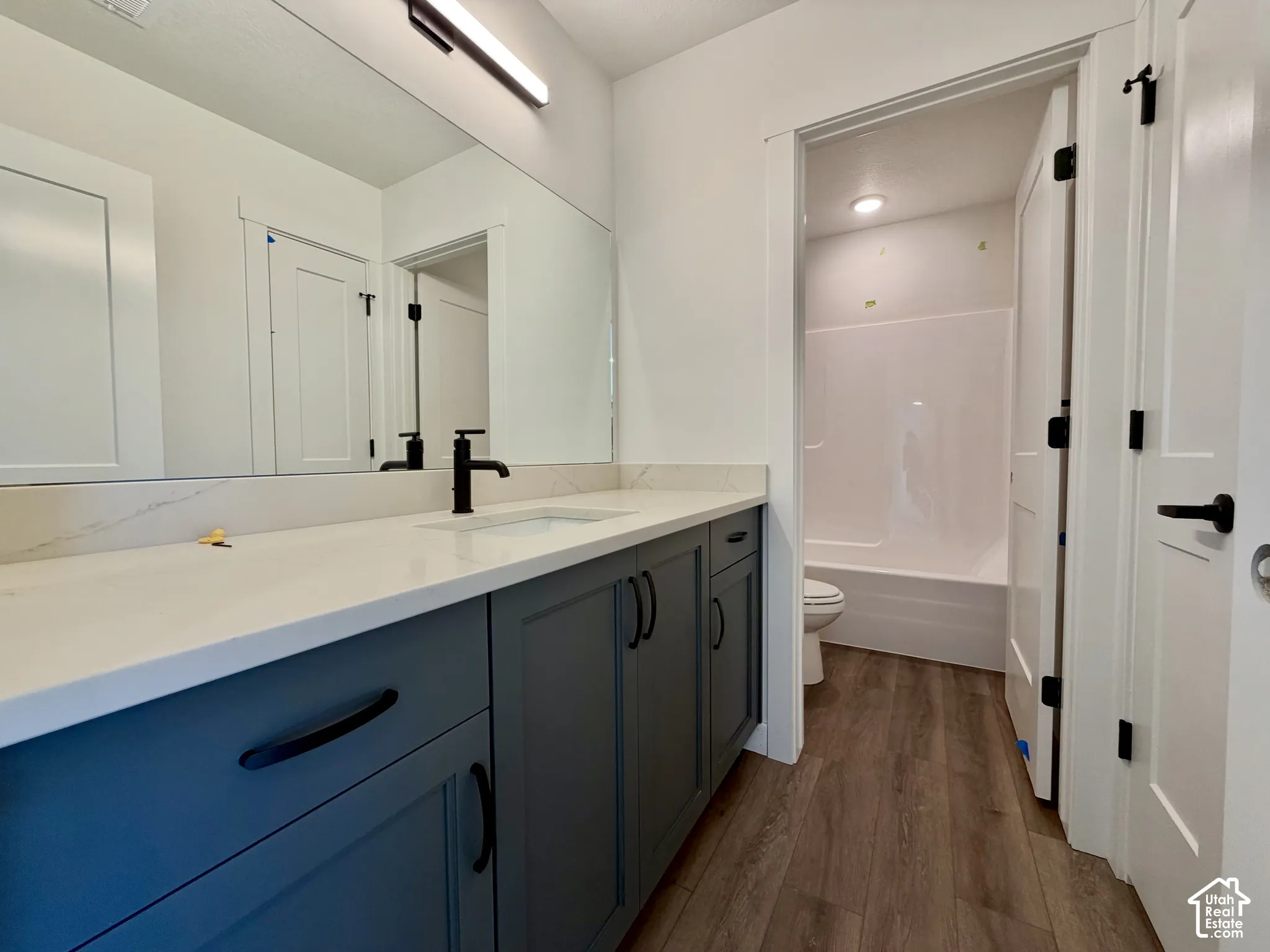 Modern bathroom featuring a vanity with a white countertop, undermount sink, and matte black faucet