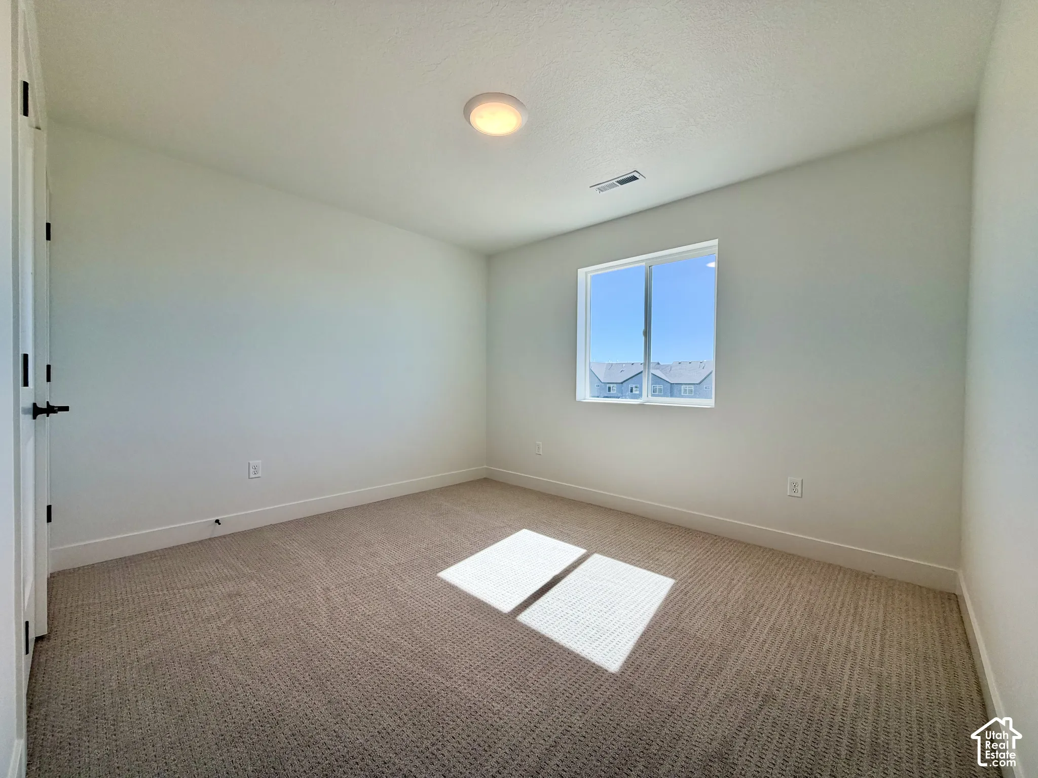 Neutral wall paint, plush carpet flooring, white trim, recessed lighting, and a double-pane window