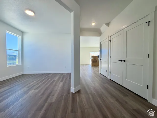Wood-finish flooring, white walls, recessed lighting, and white interior doors with matte black hardware