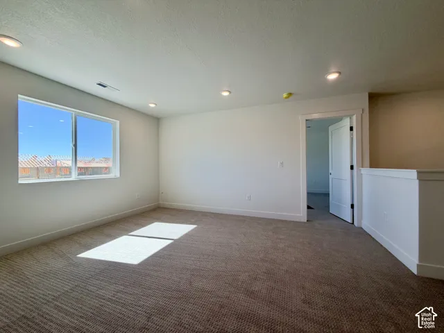 Recessed ceiling lighting, durable carpet flooring, a spacious window, and a modern interior door