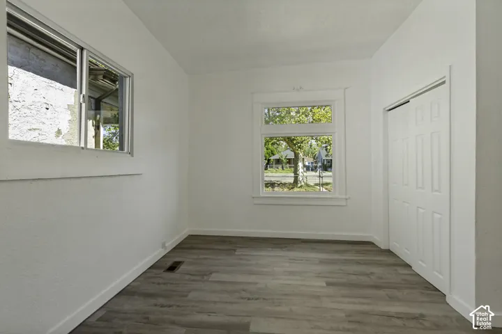 Light wood-finish flooring, white walls, and a window with white trim