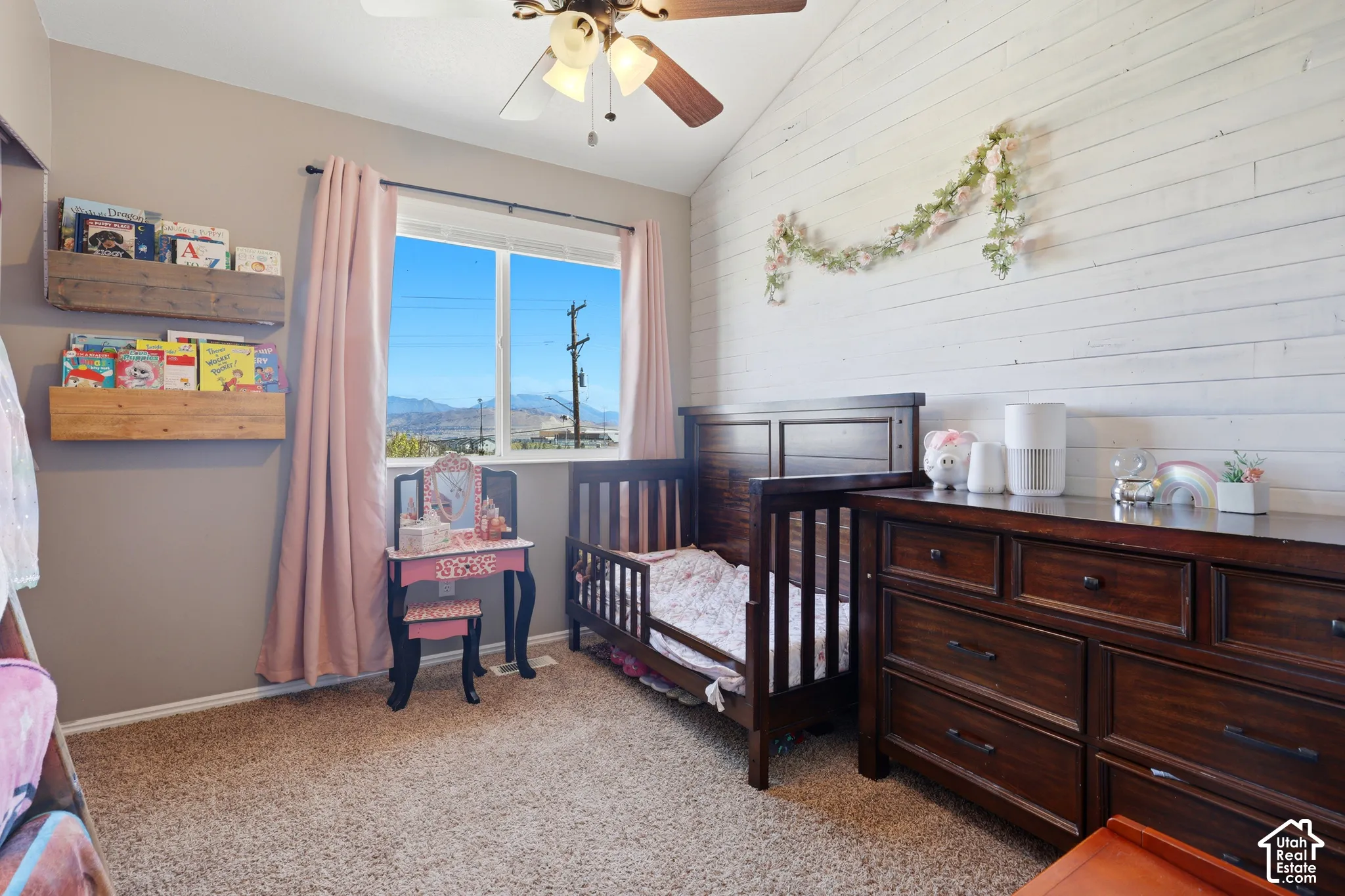 Vaulted ceiling featuring a ceiling fan, carpeted flooring, and a large window