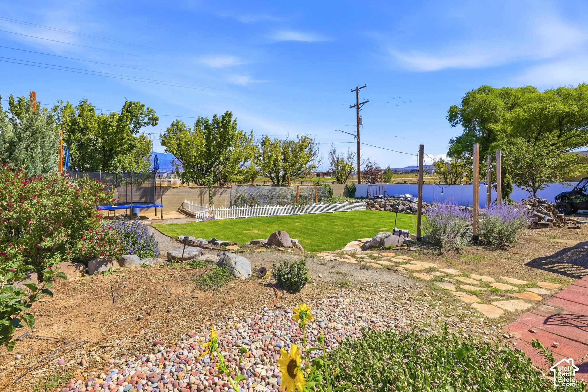 Expansive property featuring a manicured lawn area, a white picket fence, and a flagstone pathway