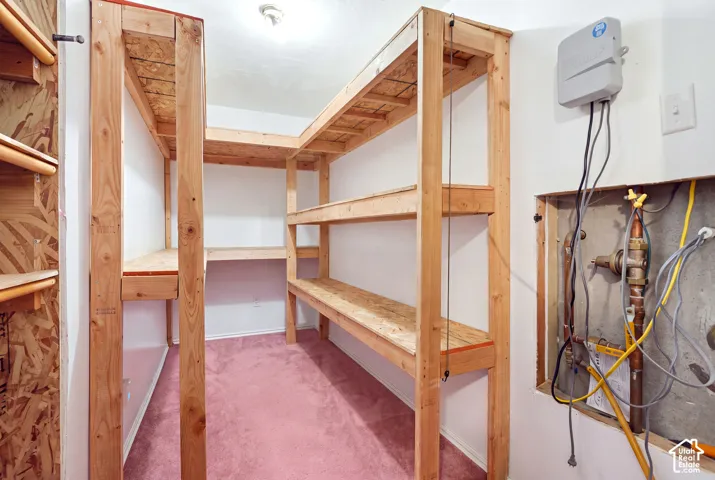 Built-in wooden shelving units, wall-mounted utility controls, and recessed lighting