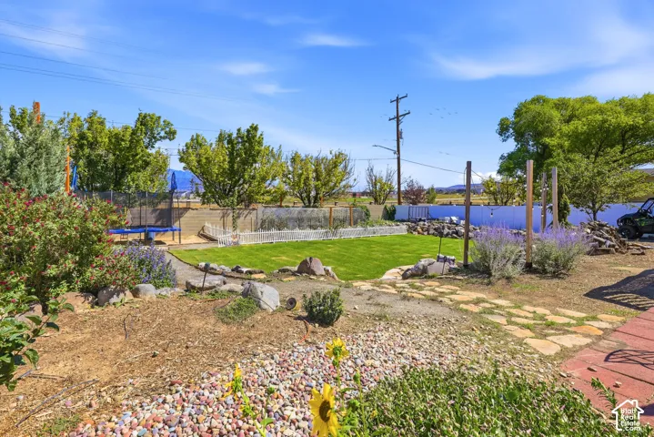Expansive property featuring a manicured lawn area, a white picket fence, and a flagstone pathway