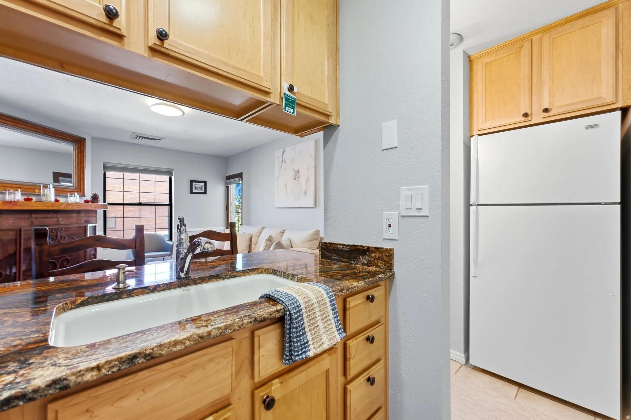 Kitchen with a white undermount sink, a chrome faucet, and natural wood cabinetry