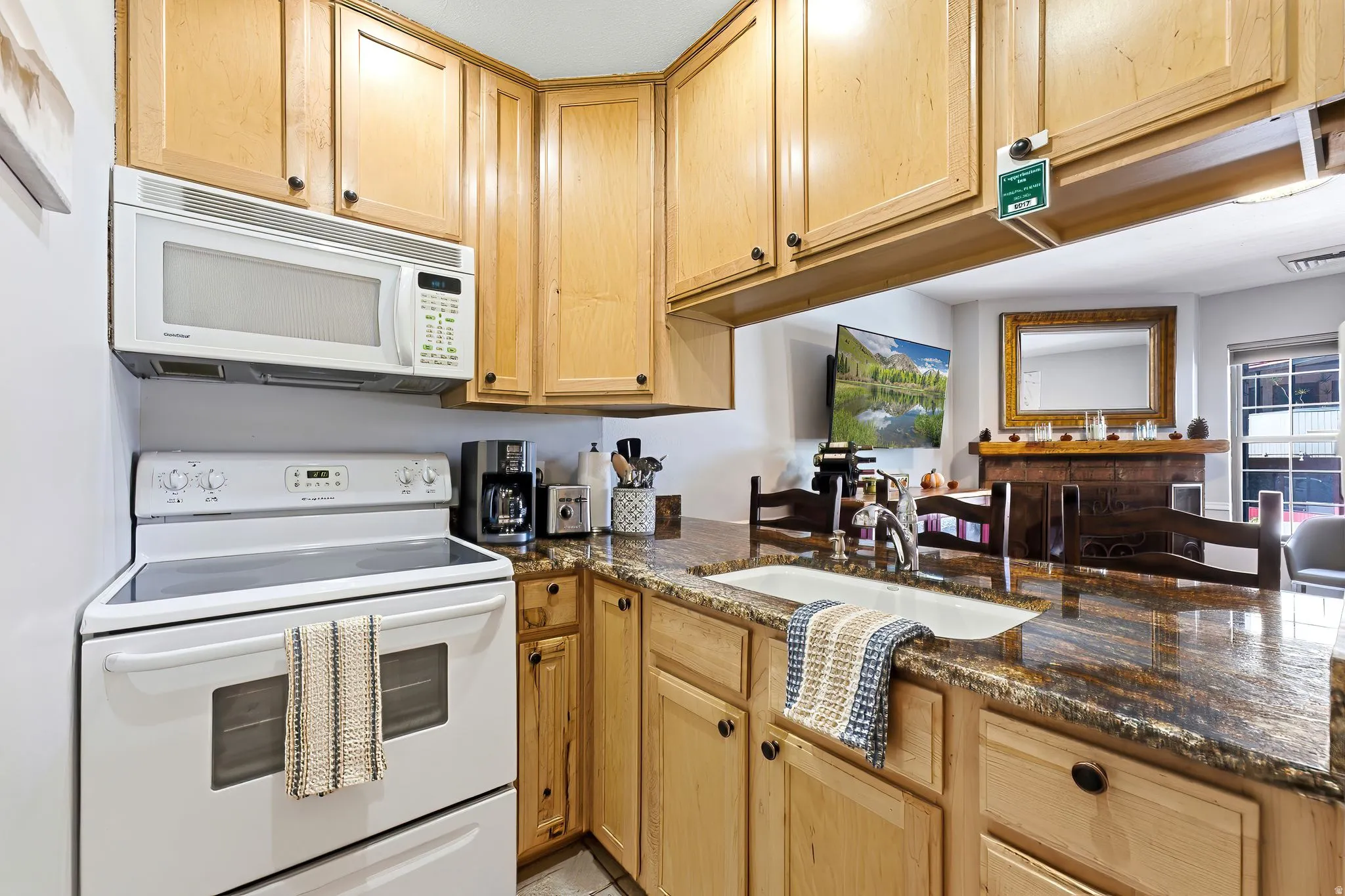 Kitchen featuring wood cabinetry, integrated white appliances, a built-in microwave, and stone countertops