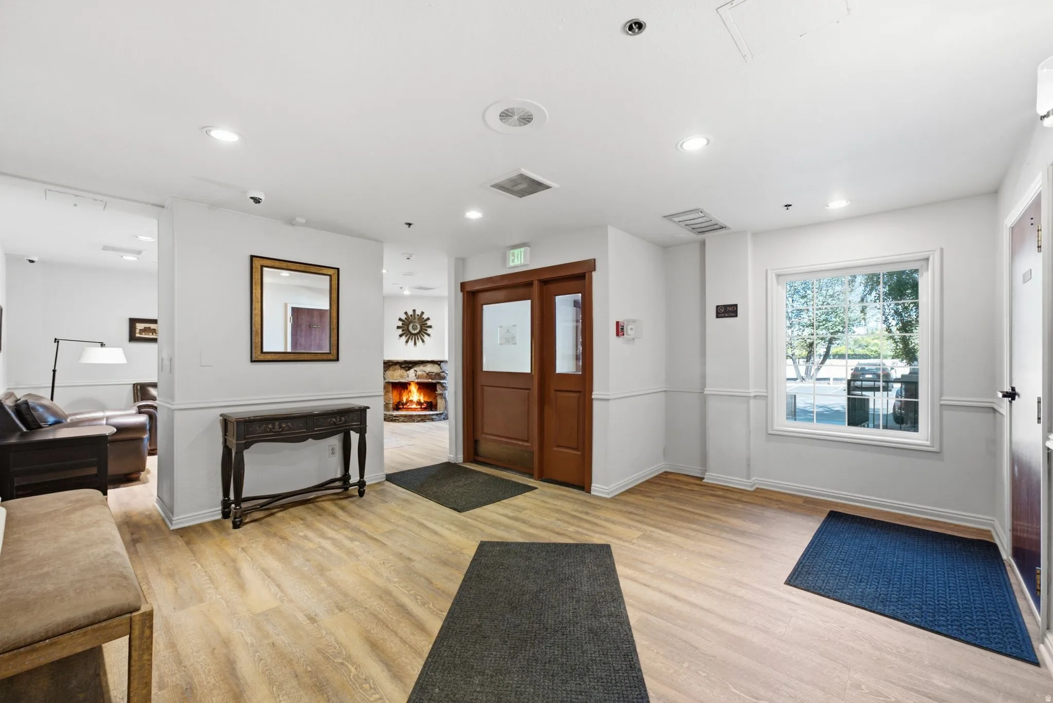 Wood-finish flooring throughout, recessed lighting, and a stone fireplace feature