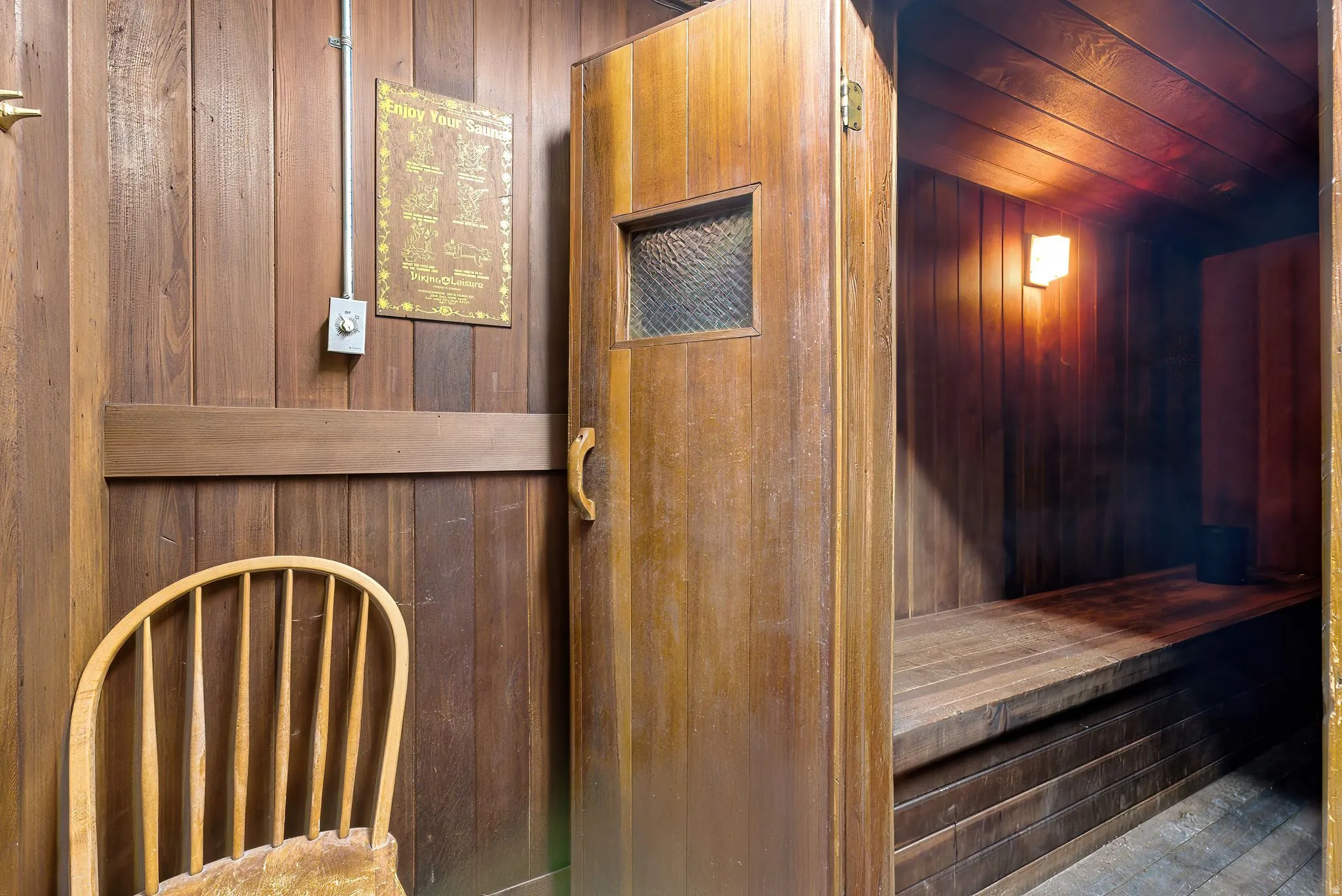 Wood-paneled room featuring a built-in sauna with wood bench seating