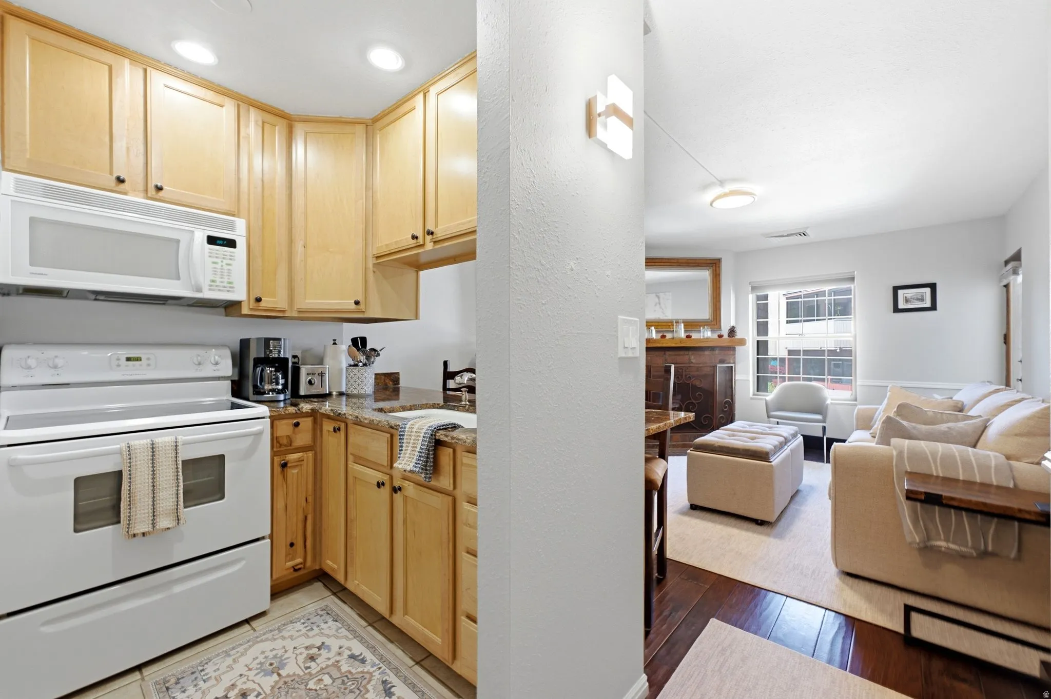 Kitchen featuring wood cabinetry, white appliances, and a granite-style countertop