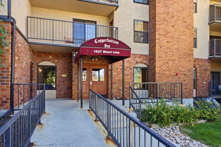Brick facade building with a red awning entrance and glass doors