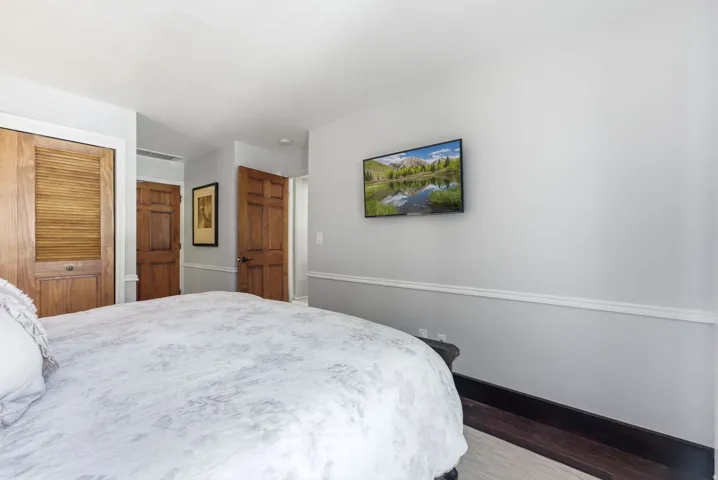 Recessed lighting, wood-finish flooring, wood doors, and white crown molding