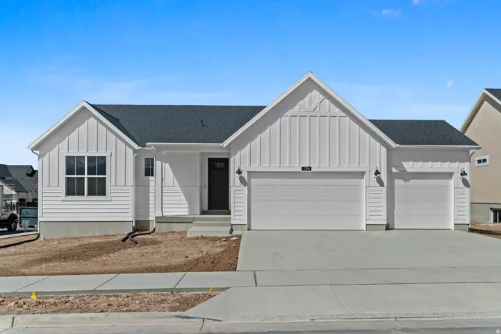 Modern farmhouse exterior with white board and batten and horizontal siding, a dark asphalt shingle roof, a two-car garage, and an additional one-car garage