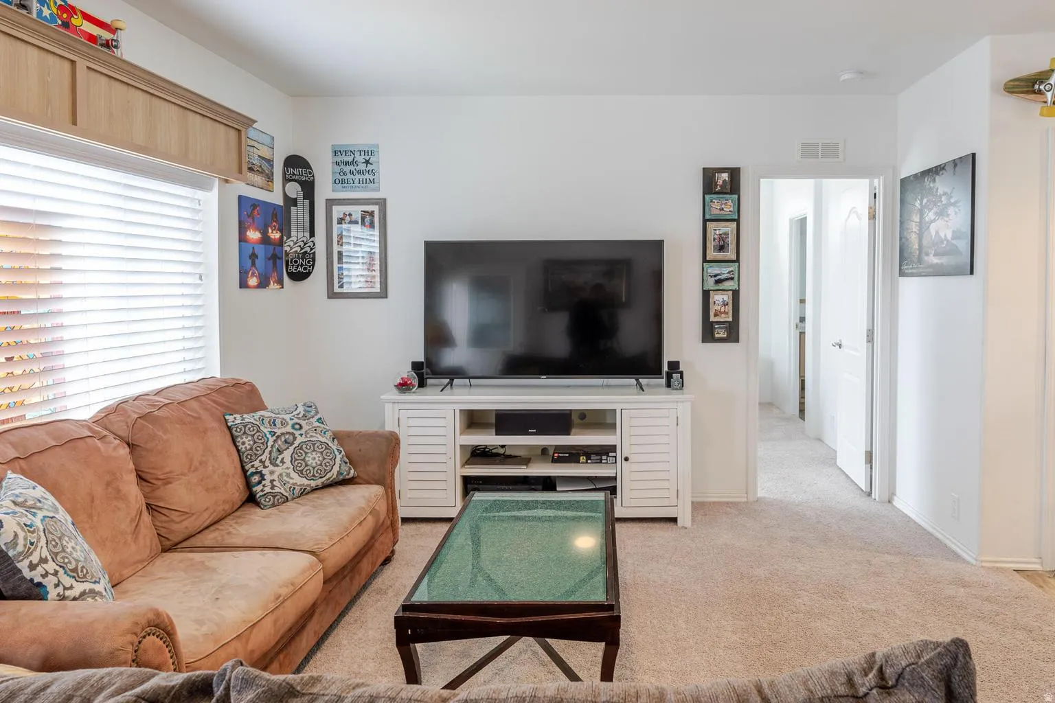 Recessed wood-finish cabinetry, neutral wall paint, and light-colored carpeting
