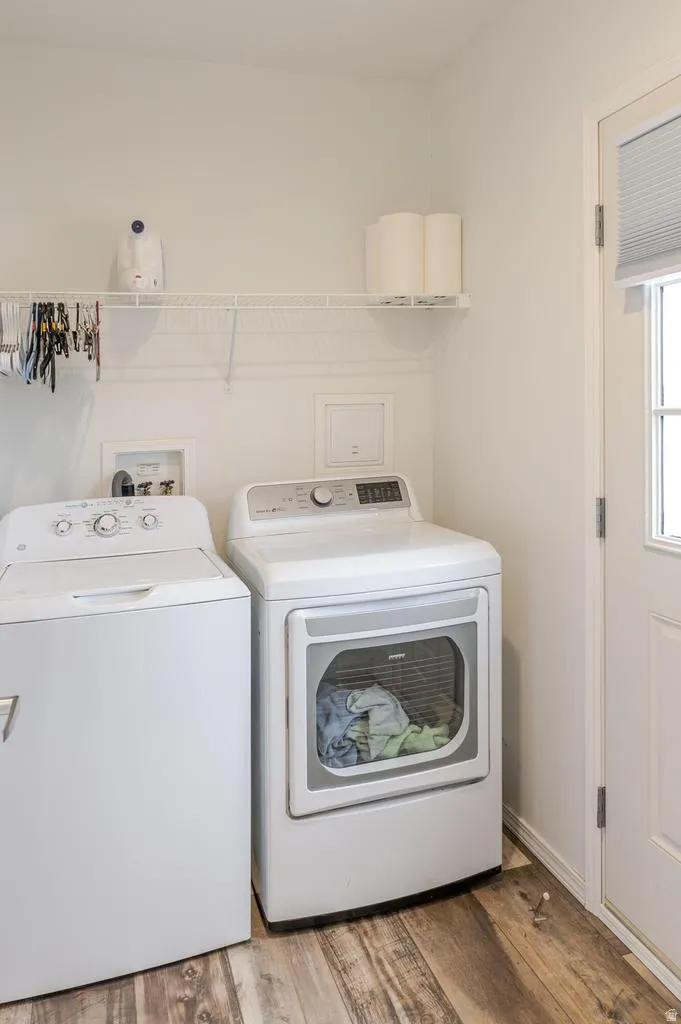Laundry area featuring wood-finish flooring, white walls, and a white wired shelf