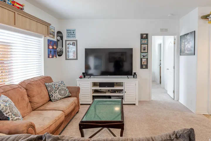 Recessed wood-finish cabinetry, neutral wall paint, and light-colored carpeting