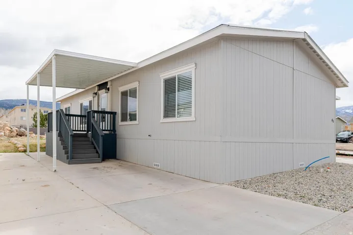 Light gray vertical siding exterior with white trim windows