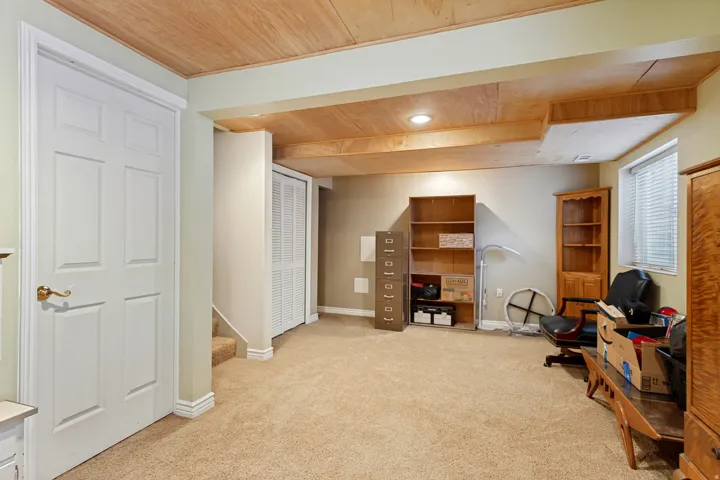 Carpeted floor with a wood-paneled ceiling, recessed lighting, and a window with blinds