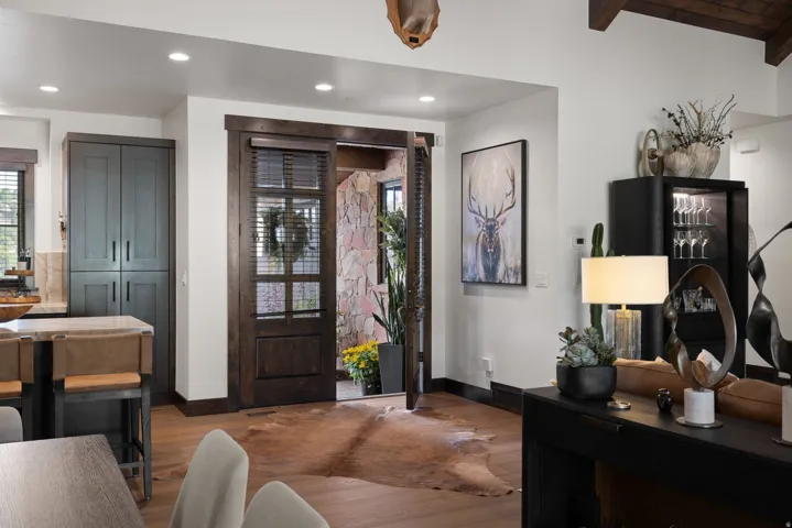 Hardwood flooring, stone accent wall, recessed lighting, exposed ceiling beams, built-in cabinetry