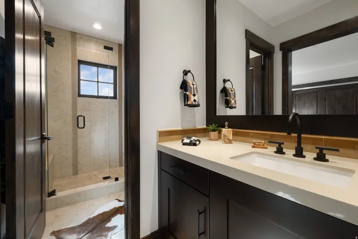 Dark wood-finish vanity with an integrated sink, light-toned countertop, and matte black fixtures