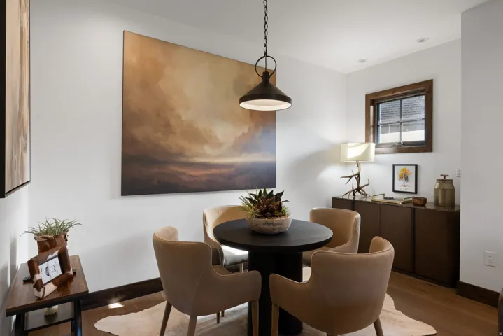 Hardwood flooring, recessed lighting, dark wood-frame window, built-in dark wood cabinetry, and a dark metal pendant light fixture