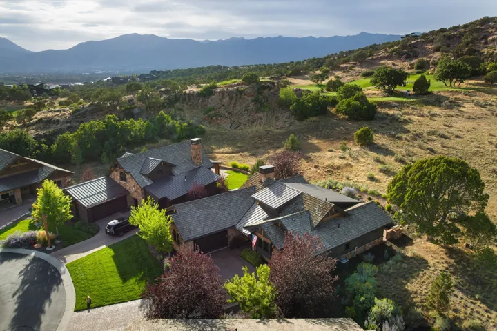 Stone and wood-sided residence with multiple gables and a dark shingle roof