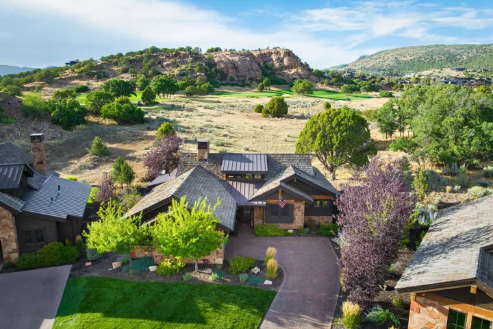 Stone and wood-finish exterior with a gabled roof and a paved driveway
