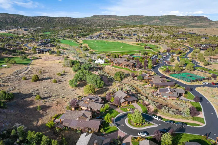 Expansive residential area with a golf course, tennis courts, and custom homes nestled into the mountainous terrain
