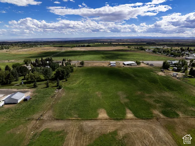 Expansive land parcel featuring open fields and distant structures