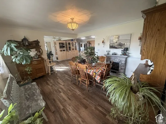 Wood-finish flooring, stone-veneer fireplace, ornate semi-flush mount light fixture, and built-in cabinetry