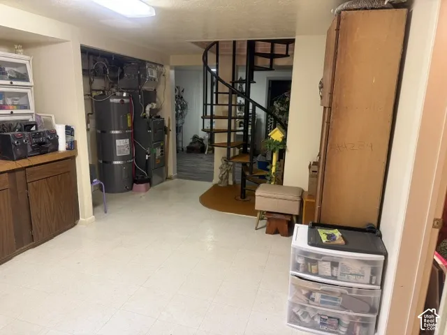 Spiral staircase with black metal frame, built-in cabinetry, and mechanical area