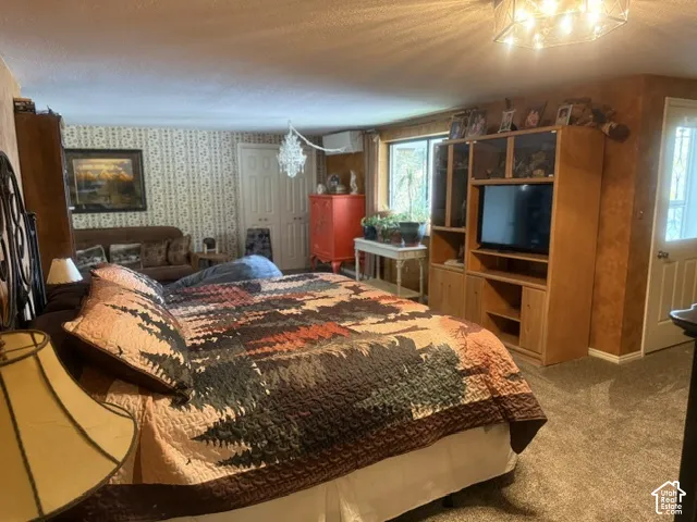 Wall-to-wall carpeting, built-in wooden cabinetry, wall-mounted air conditioning unit, and flush-mount ceiling lighting