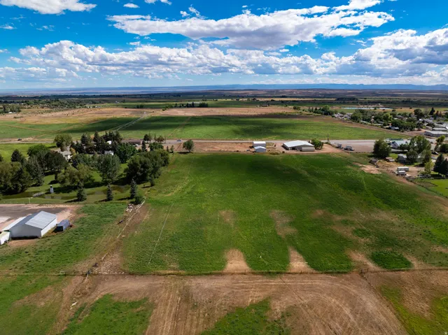 Expansive land parcel featuring open fields and distant structures