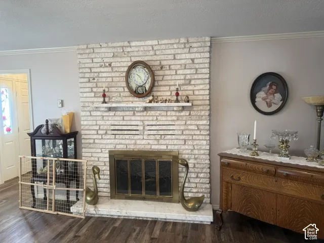 Floor-to-ceiling textured brick fireplace featuring a stone hearth and integrated mantle