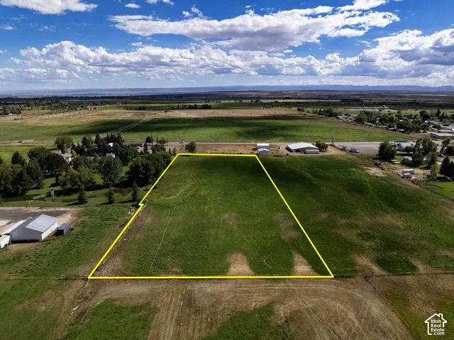 Expansive open land with delineated boundaries, surrounded by agricultural fields and distant structures