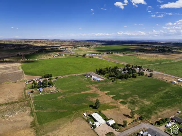 Extensive agricultural land with varied terrain, featuring cultivated fields and scattered structures