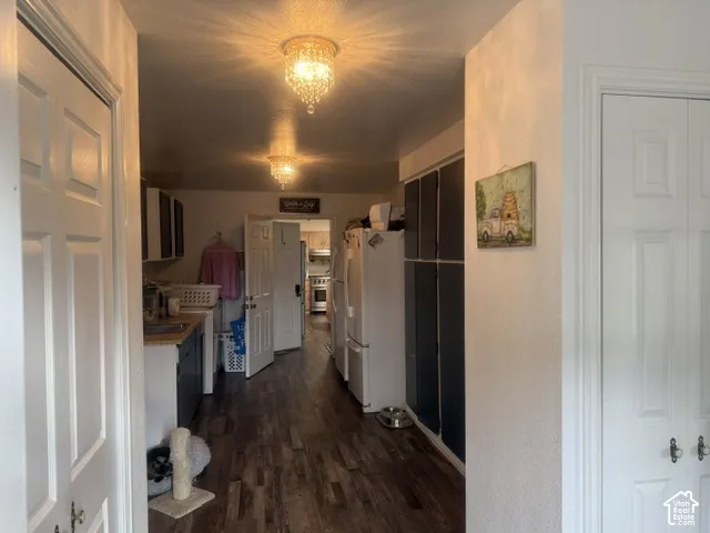 Wood-finish flooring, dual crystal-accented flush-mount light fixtures, and multiple sets of white paneled doors