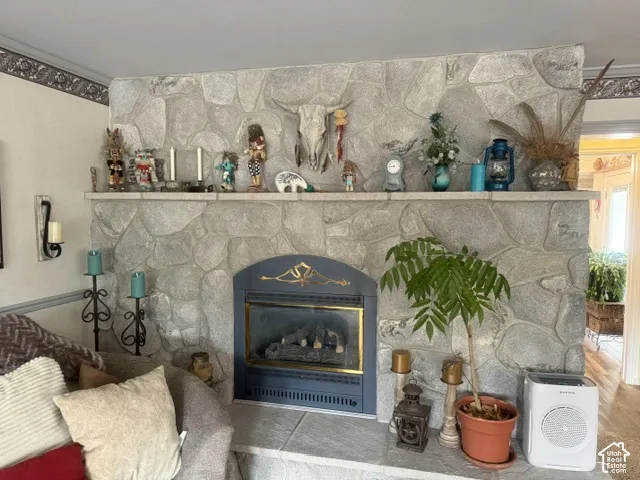 Floor-to-ceiling stone masonry fireplace surround featuring a built-in stone mantel and elevated hearth