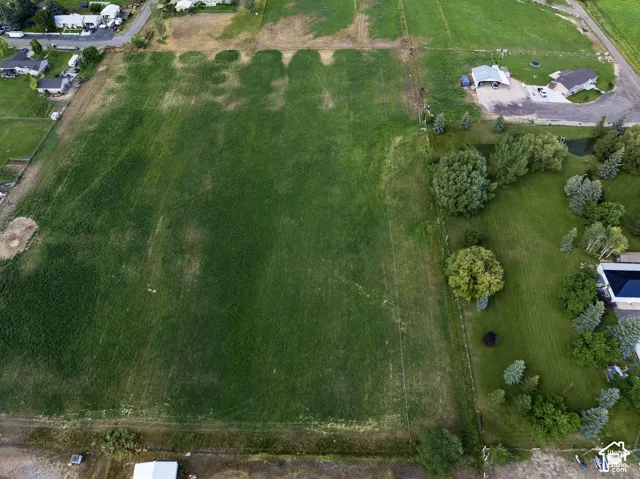 Expansive green field with surrounding residential properties, mature trees, and landscaping