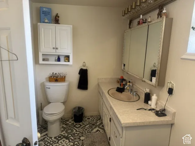 Vanity featuring a light-toned countertop, integrated oval basin, and triple-door medicine cabinet