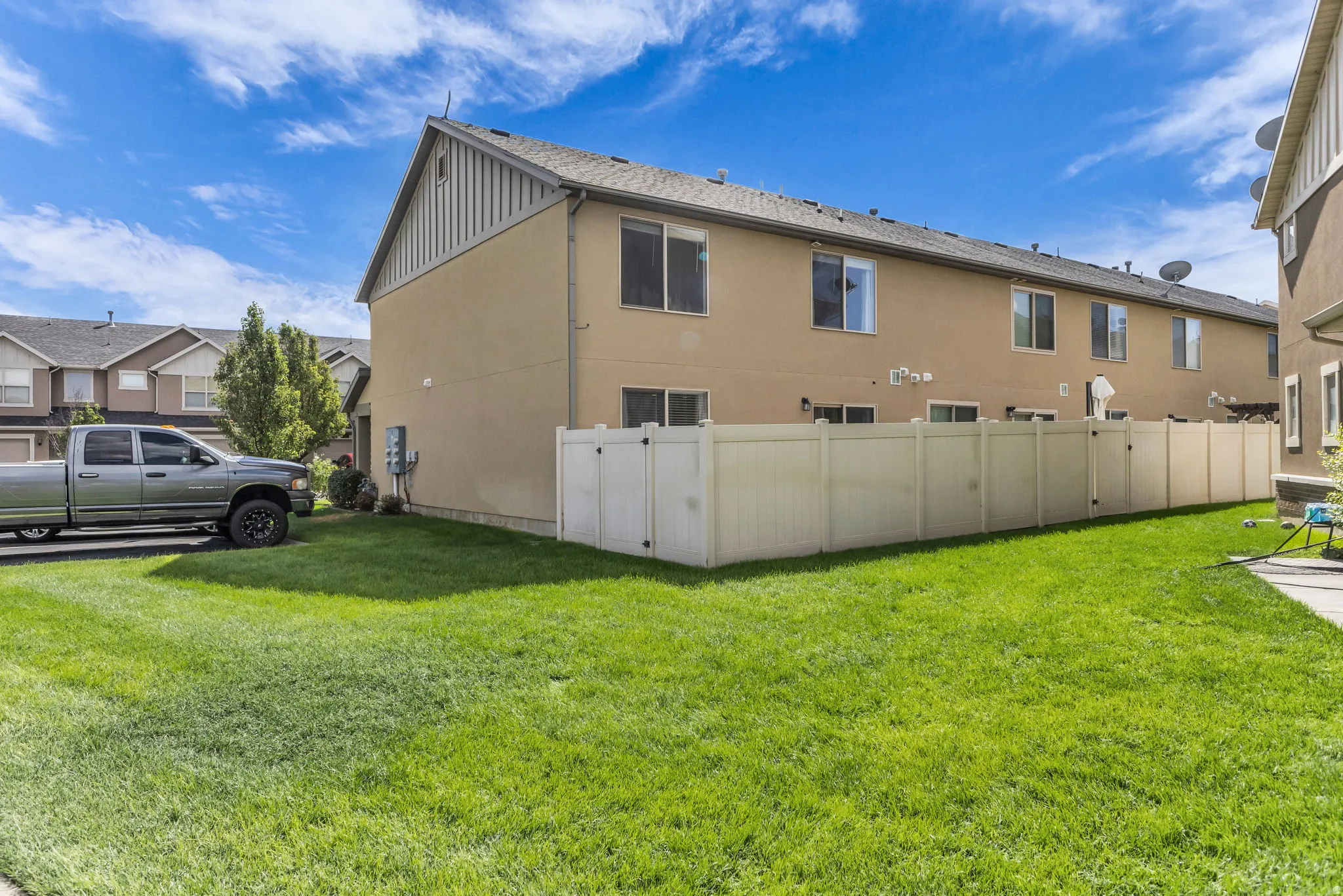 Expansive grassy area with a vinyl privacy fence