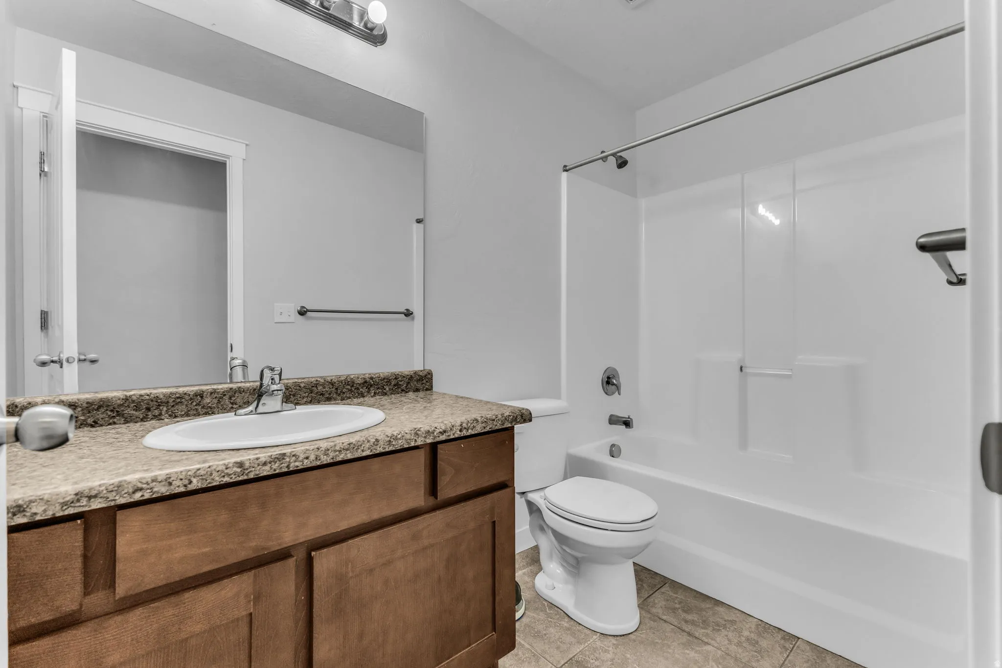 Vanity with a brown wood-finish cabinet and a speckled countertop