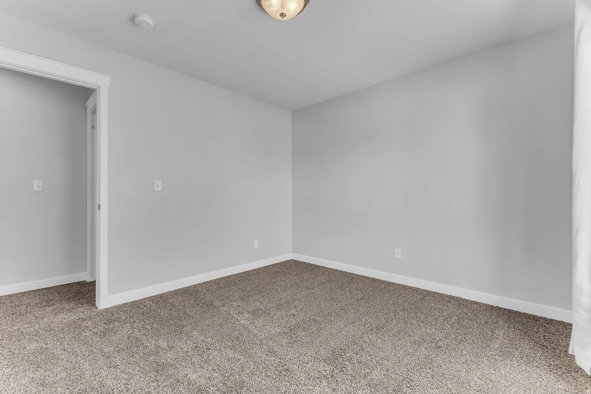 Neutral-toned carpeting, light gray wall finishes, and white trim
