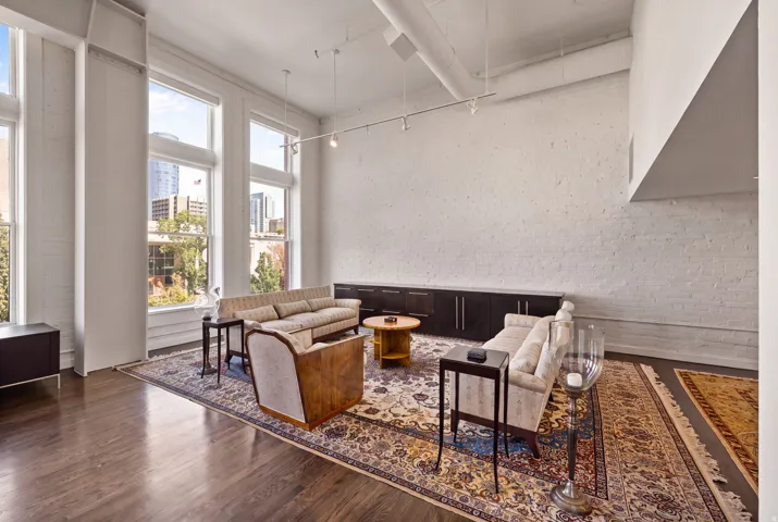 Hardwood flooring, painted brick wall, high ceilings, exposed ductwork, large windows